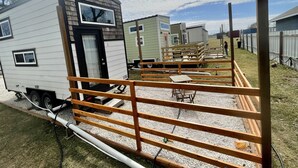 Uma fileira de casas móveis com um caminho de pedras e cerca de madeira.