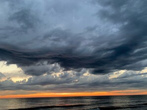 Atardecer costero con cielos nublados.