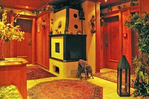 A room with a fireplace, wooden walls, and a rug.