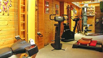 Un gimnasio con equipo de ejercicio, paredes de madera y trofeos.