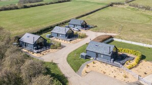 A modern farmhouse with three main buildings, a driveway, and surrounding fields. - Eagles Peak (Pickering)