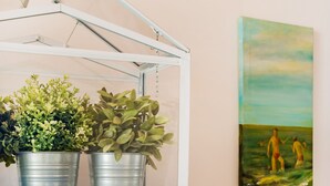 A blue cabinet with a metal plant stand containing three potted plants. - 1BR Apartment - Downtown Lisbon - Chiado (Lisbon)