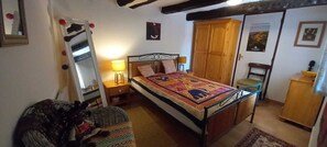 A bedroom with a bed, a wardrobe, a chair, a nightstand, and a lamp. - Whole cozy country cottage in South of France. (Frausseilles)