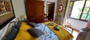 Ein Zimmer mit einem Bett, einem Kleiderschrank, einem Spiegel und einem Fenster.