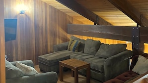 A cozy room with a wooden ceiling, a sofa set, a wooden coffee table, and a cushioned bench. - RR18 National Forest Views! (Black Butte Ranch)