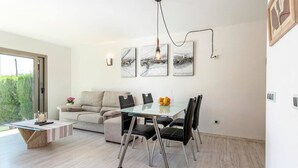 Un espace repas moderne avec une table en verre, des chaises noires et un design minimaliste.