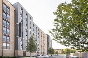 A multi-story residential building with a brick facade, balconies, and a clear street view. - Yugo Explore - Arran House (Edinburgh)