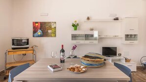 Ein modernes Wohnzimmer mit einem Holzesstisch, einem Fernseher und einem Bücherregal.