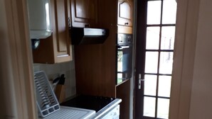 Una cocina con armarios de madera, lavavajillas y estufa.