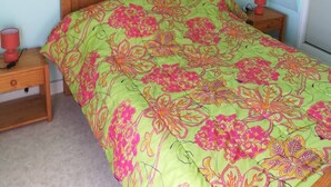 Un dormitorio con una cama, dos mesitas de noche y un tocador.