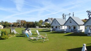 A residential area with a grassy lawn, a swing set, and a small playground. - Holiday homes with terraces, close to the beach (Ustronie Morskie)