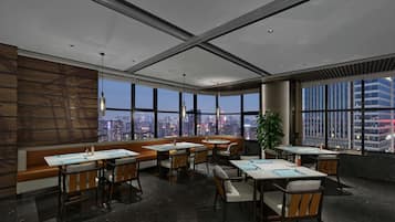 A modern conference room with large windows, a high ceiling, and a city view.