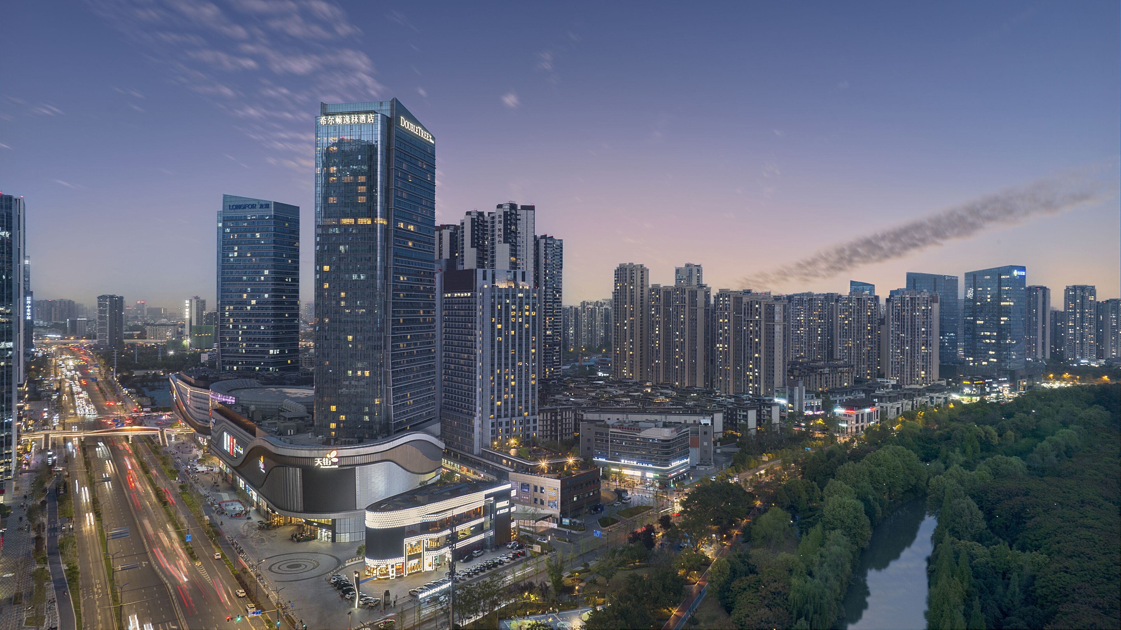 A high-rise hotel with multiple floors, a modern architectural design, and a view of a river.