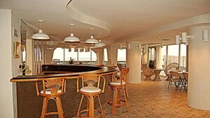 Una cocina amplia con una isla curva, taburetes de bar e iluminación colgante.
