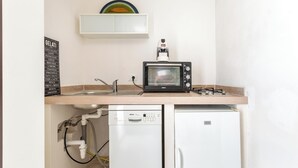 A compact kitchenette with a built-in dishwasher, a small refrigerator, and a toaster oven.