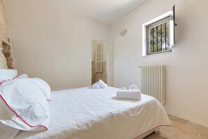 Ein Hotelzimmer mit Bett, Fenster, Heizkörper und Spiegel.