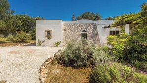 A single-story building with a stone facade, a small window, and a door.