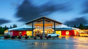 A hotel with a red facade, large windows, and a covered entrance. - Quality Inn & Suites (Clearwater)