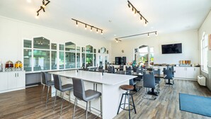 A spacious kitchen with a large island, bar stools, and a dining area with chairs. - Quality Inn & Suites (Clearwater)