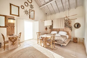 A room with a bed, wooden furniture, a dining table, and a chandelier. -  Quinta do Porto Nogueira (Cadaval)