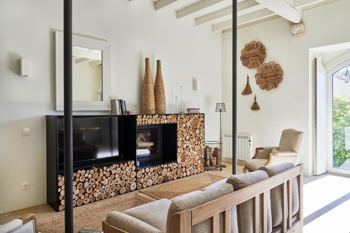 A living room with a fireplace, a large mirror, and a sofa.