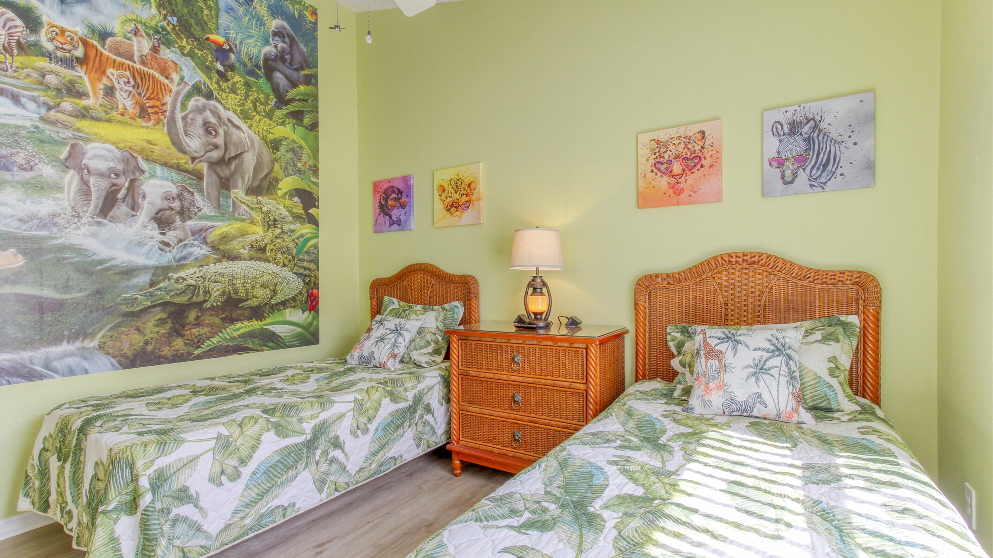 A bedroom with two beds, a nightstand, and a wall mural.