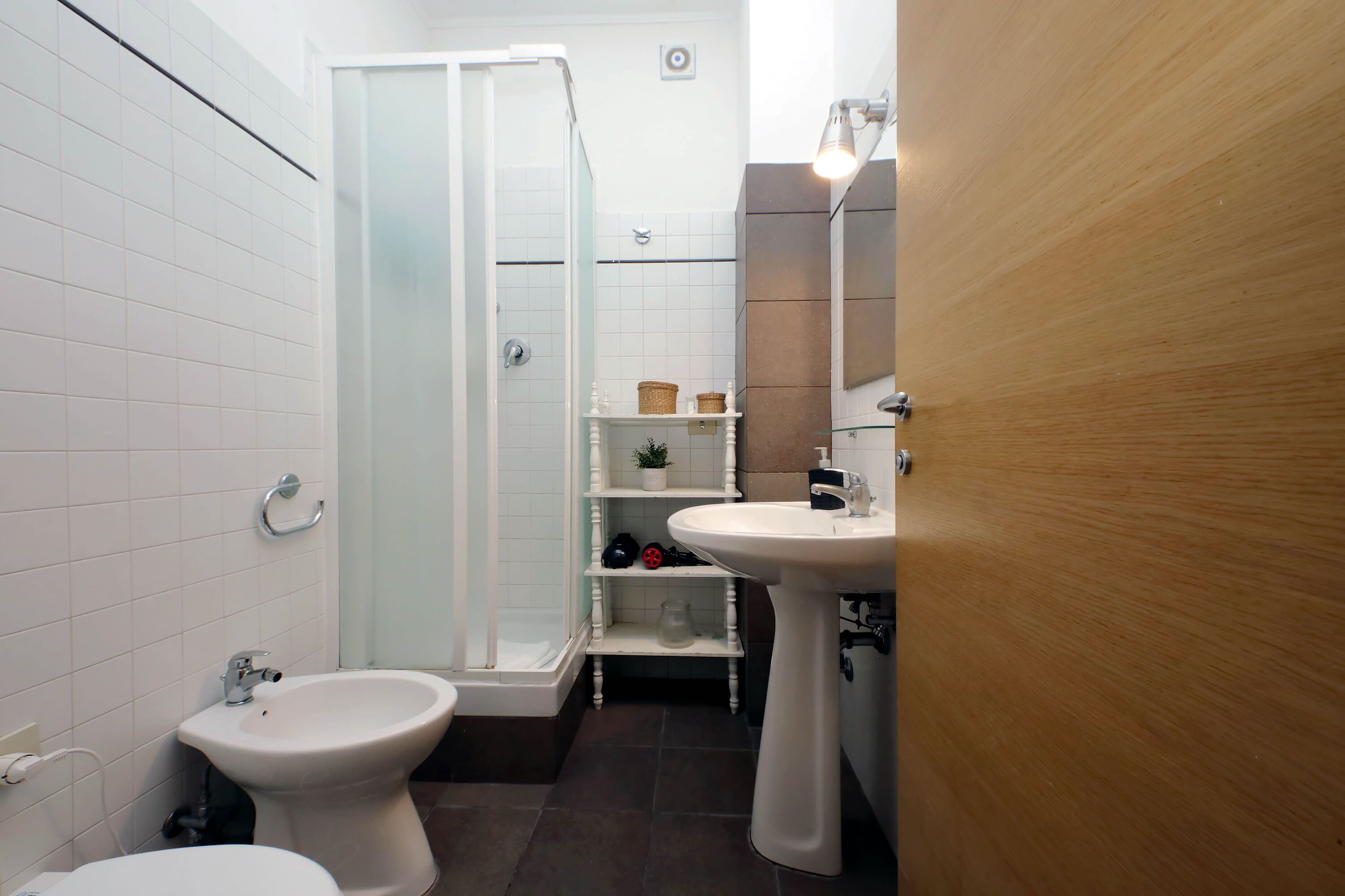 Ein Badezimmer mit Dusche, Bidet und Waschbecken.