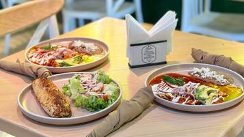 A table with two plates of food, a napkin, and a menu.