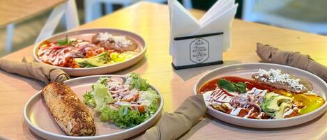 Une table avec deux assiettes de nourriture, une serviette et un menu.