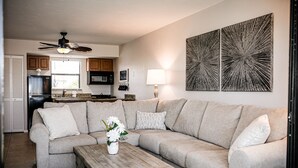 A living room with a beige sectional sofa, a wooden coffee table, and a ceiling fan. - ANGLERS COVE - WELCOME TO "ISLAND TIME" AT MARCO ISLAND (Marco Island)