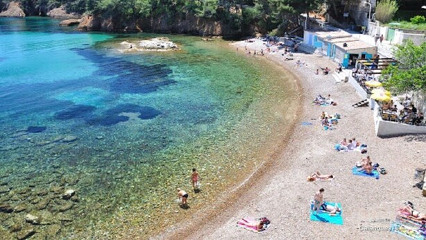 A beach with clear water, people sunbathing, and buildings in the background. - VILLA ANDALUCIA, Air-conditioned, Heated pool, Sea view of calanques. Sleeps 6 (La Ciotat)