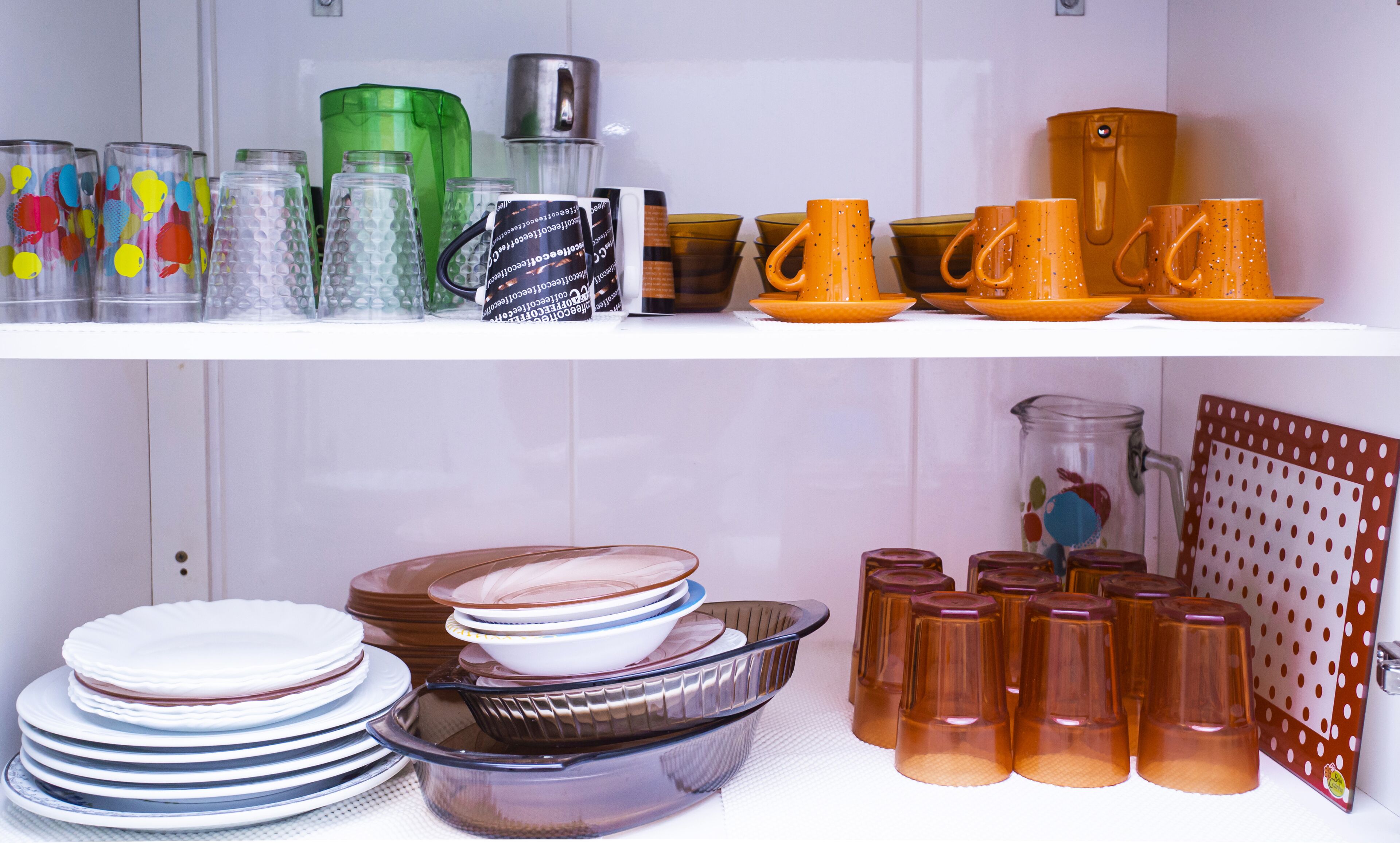 Una cocina con diferentes vasos y vajilla en estantes.