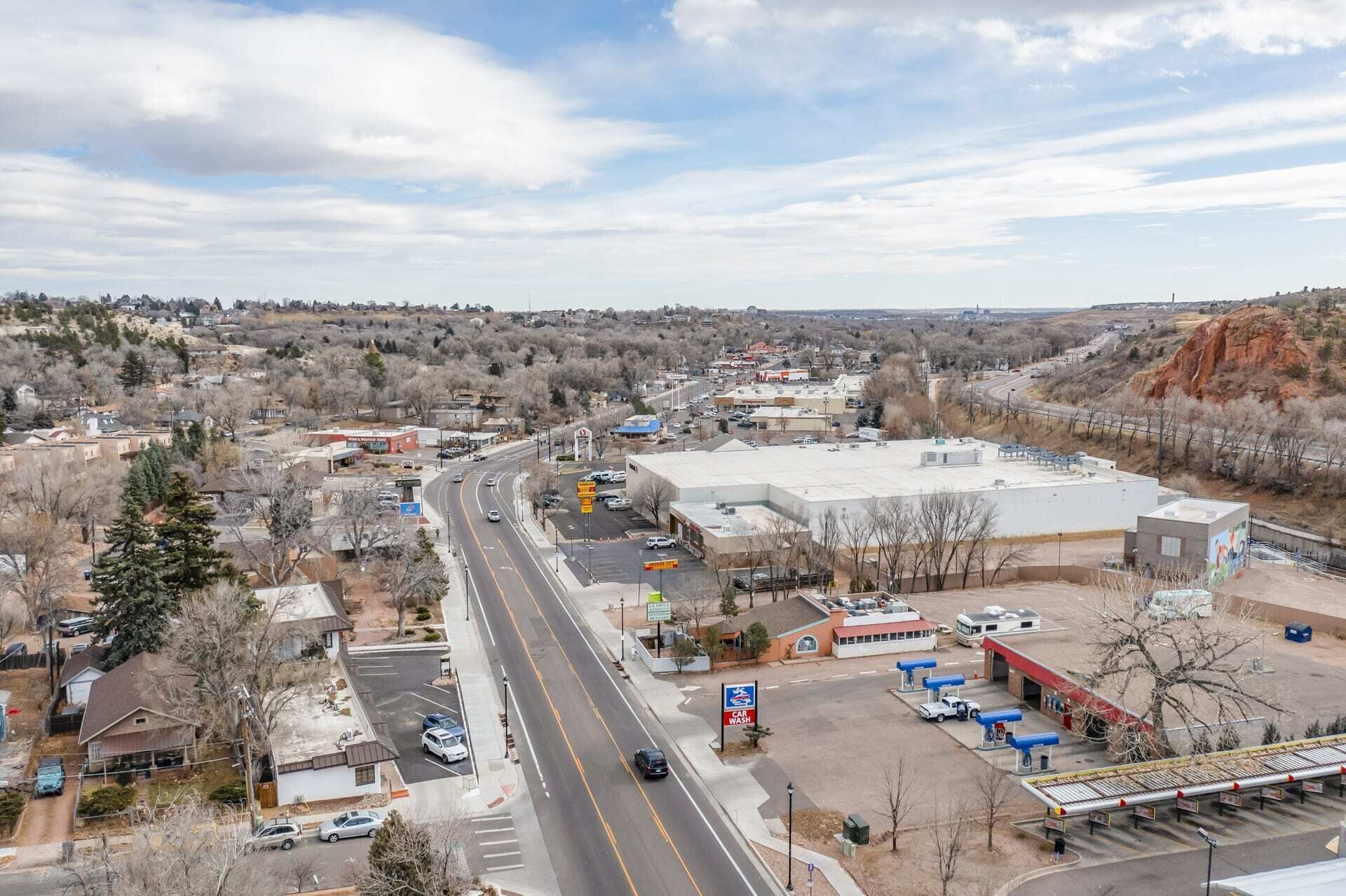 Une zone commerciale comprenant une station-service, un grand bâtiment et une route.