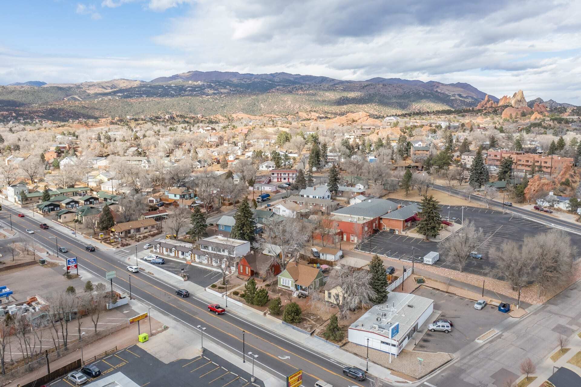 A town with a main road, buildings, and mountains in the background.