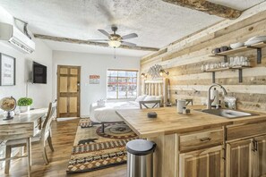 A rustic kitchen with wooden cabinetry, a central island with a sink, and a ceiling fan. - 1BD Suitenear Old Colorado City & Hiking!dogs Welcome! (Colorado Springs)