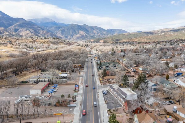 A town with a main road, buildings, and mountains in the background.