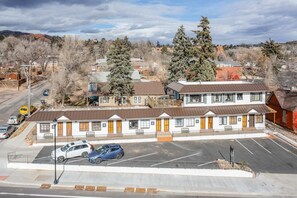 A motel with a row of rooms, a parking lot, and a mountainous backdrop. - 1BD Cozy Suiterestaurants & Hiking!dogs Welcome (Colorado Springs)