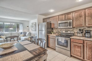 Enjoy cooking in this well-equipped kitchen with a refrigerator, microwave, and oven, complemented by a large island with a sink.