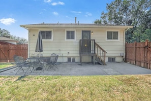 A two-story house with a patio area, a small staircase, and a fenced backyard. - 4brnear Garden Of The Gods With Large Yard (Colorado Springs)