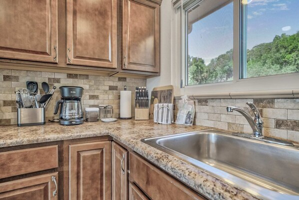 Enjoy cooking in this well-equipped kitchen with a sink, coffee maker, and ample storage.