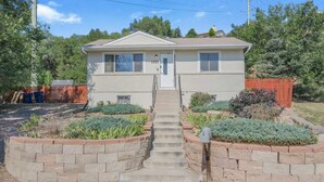 A single-story house with a front entrance, a small front yard with a brick planter, and a mailbox.