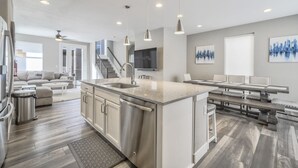 A modern kitchen with a central island, stainless steel appliances, and pendant lighting. - 3BD Rooftop Lounge Restaurants & Parks (Castle Rock)