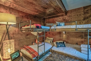 A bunk bed room with wooden walls, a lamp, and a small table. - 3brsweet & Chic Getawayminutes To Hiking (Monument)