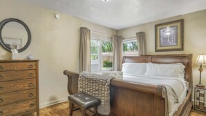 A bedroom with a wooden bed, a dresser, a mirror, and a window with curtains. - 2BR Manitou Get Away Close To Everything! (Manitou Springs)