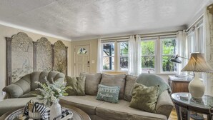 A cozy living room with a sofa, a coffee table, and a lamp. - 2BR Manitou Get Away Close To Everything! (Manitou Springs)