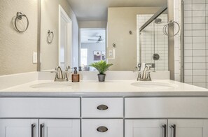 A bathroom with two sinks, a potted plant, and a mirror. - 3BD Modern Home Close to Usafa (Monument)