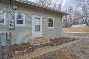A single-story house with a front door, a small porch, and a mailbox.