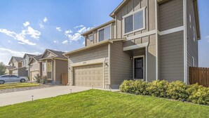 A two-story townhouse with a garage, a well-maintained lawn, and a wooden fence. - 3bdquiet Suburbsthe Perfect Get Away (Colorado Springs)