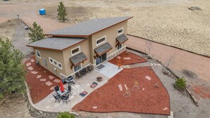 Un bâtiment à deux étages doté d’un patio comprenant un espace extérieur avec des sièges et un foyer.