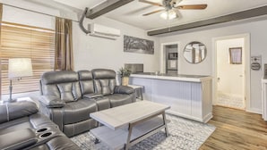 A modern living room with a leather sofa, a coffee table, and a ceiling fan. - 2BD Cozy Retreatclose to Red Rocksdogs Welcome! (Colorado Springs)